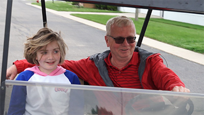 Grandfather and granddaughter in golf cart